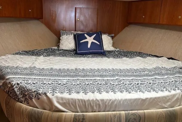 Slide: The Image of Cozy bedroom in 2000 Silverton 41 Convertible yacht with starfish-themed decor. - 18