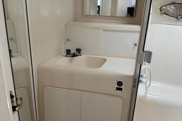 Slide: The Image of 2000 Silverton 41 Convertible yacht bathroom with sink, mirror, and shower area. - 22