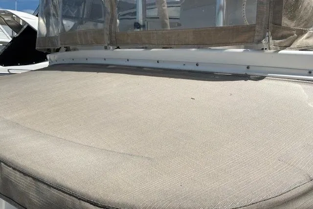 Slide: The Image of 2000 Silverton 41 Convertible boat with beige cushioned deck under clear skies. - 38