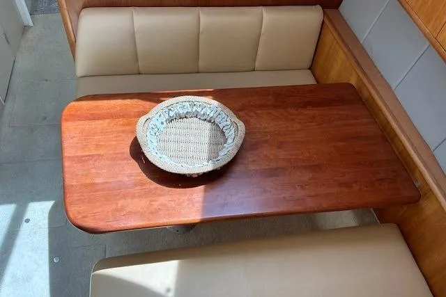 Slide: The Image of Cozy dining area in a 2000 Silverton 41 Convertible yacht with wooden table and basket. - 5