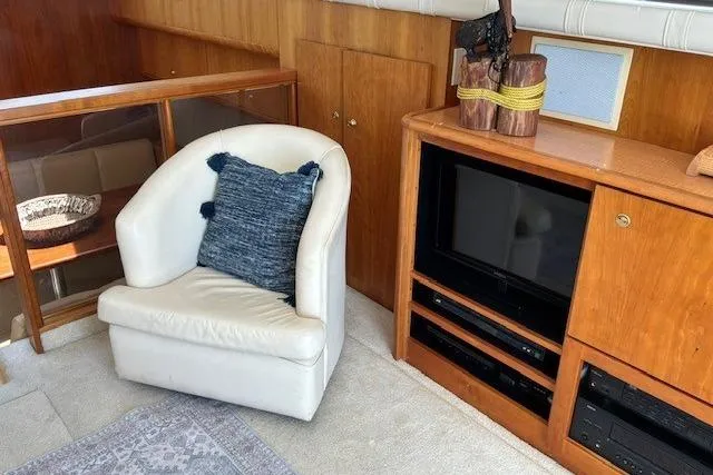 Slide: The Image of Interior of 2000 Silverton 41 Convertible yacht with chair, TV, and wooden cabinetry. - 6