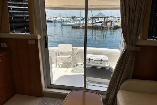 Slide: The Image of Interior view of a 2000 Silverton 41 Convertible yacht overlooking a marina through sliding glass doors. - 7