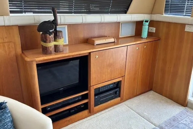 Slide: The Image of Interior of 2000 Silverton 41 Convertible yacht with wooden cabinetry and entertainment system. - 8