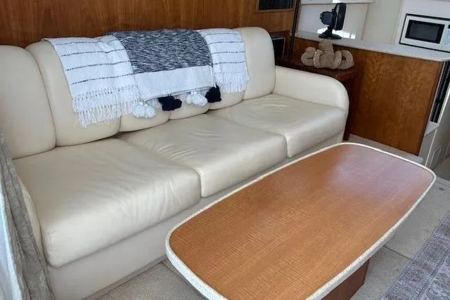Slide: The Image of Luxurious interior of 2000 Silverton 41 Convertible yacht with cream sofa and wooden table. - 9