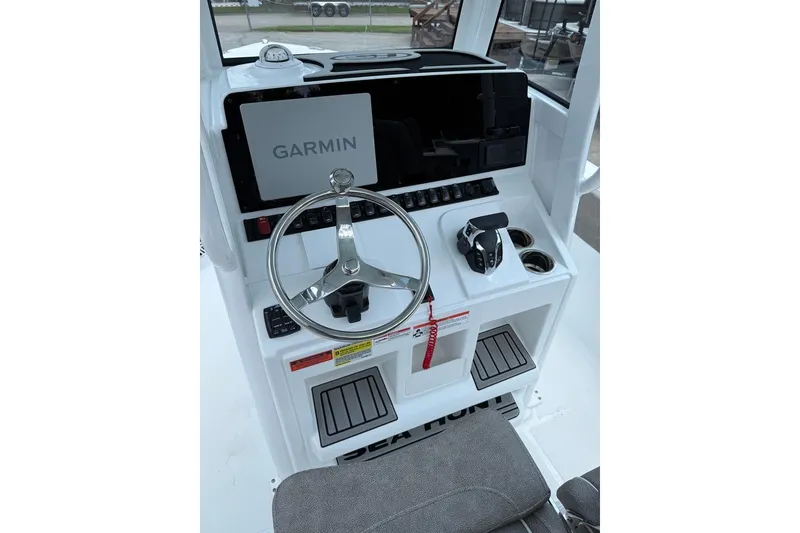 Slide: The Image of 2026 Sea Hunt Ultra 235 SE boat console with Garmin navigation system and steering wheel. - 10