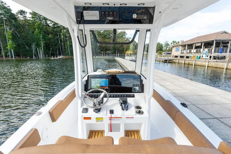 Slide: The Image of Manufacturer Provided Image: 2026 Sea Hunt Ultra 235 SE boat interior with modern dashboard and scenic marina view. - 17