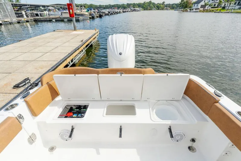 Slide: The Image of Manufacturer Provided Image: 2026 Sea Hunt Ultra 235 SE boat interior with storage compartments, docked by a marina. - 19