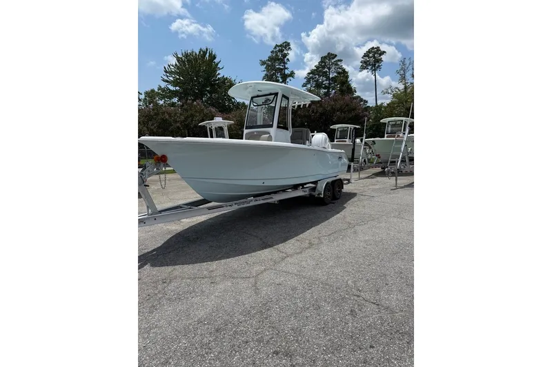 Slide: The Image of 2026 Sea Hunt Ultra 235 SE boat on trailer, parked outdoors under a cloudy sky. - 2