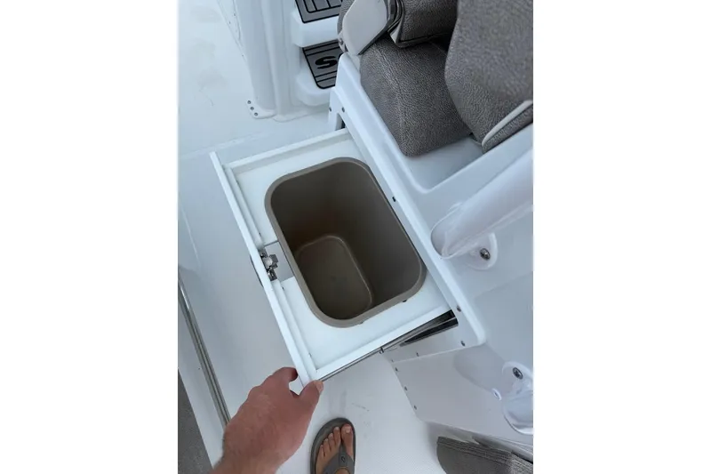 Slide: The Image of Storage compartment on 2026 Sea Hunt Ultra 235 SE boat with pull-out bin. - 7