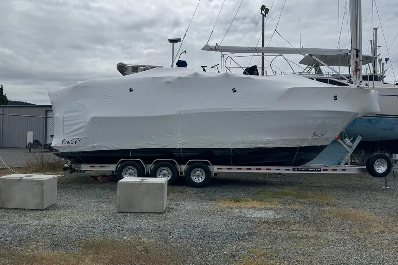 Slide: The Image of 2025 Cutwater C-288 Coupe boat covered on trailer in a boatyard. - 1