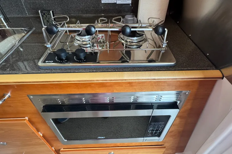 Slide: The Image of Kitchen area of 2025 Cutwater C-288 Coupe with stove and microwave. - 11