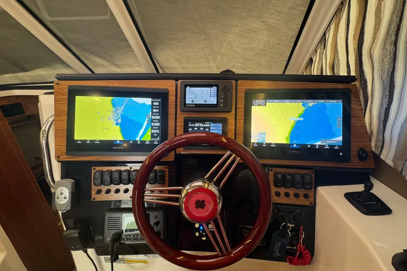 Slide: The Image of 2025 Cutwater C-288 Coupe dashboard with navigation screens and steering wheel. - 5
