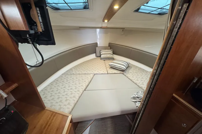 Slide: The Image of 2025 Cutwater C-288 Coupe interior cabin with cozy seating and striped cushions. - 8