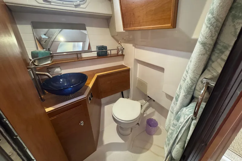 Slide: The Image of 2025 Cutwater C-288 Coupe bathroom with modern sink, toilet, and wooden cabinetry. - 9