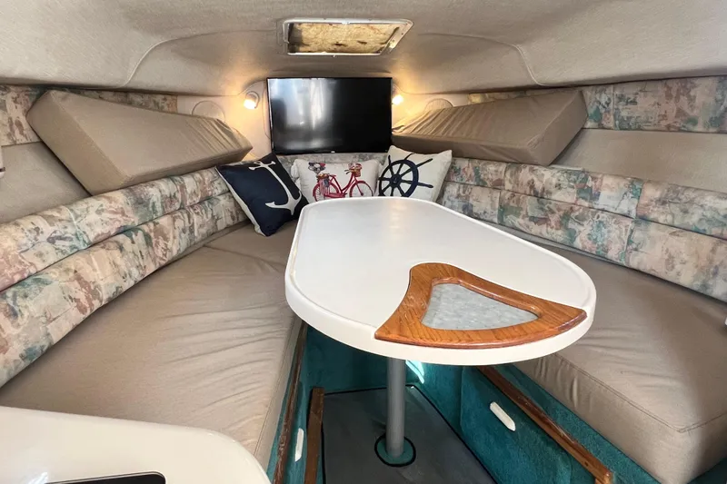 Slide: The Image of Interior of 1997 Sea Ray 270 Sundancer with cozy seating and nautical-themed decor. - 13
