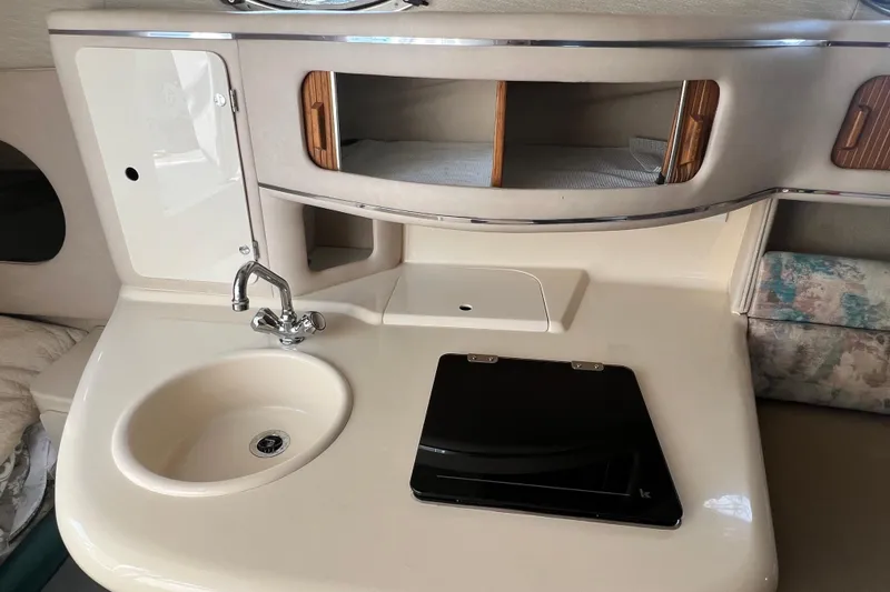 Slide: The Image of Interior of a 1997 Sea Ray 270 Sundancer boat with sink and storage. - 14