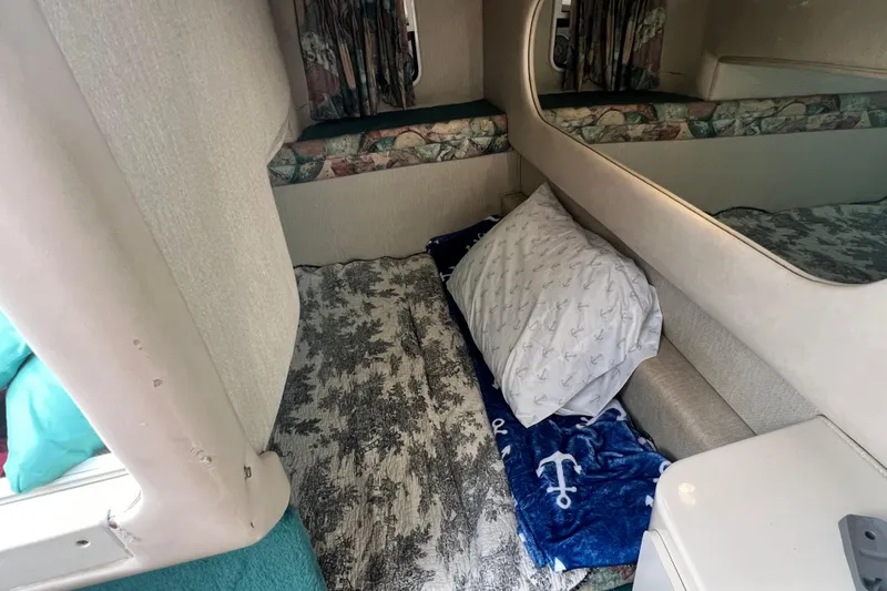 Slide: The Image of 1997 Sea Ray 270 Sundancer cabin interior with bedding and nautical-themed decor. - 17