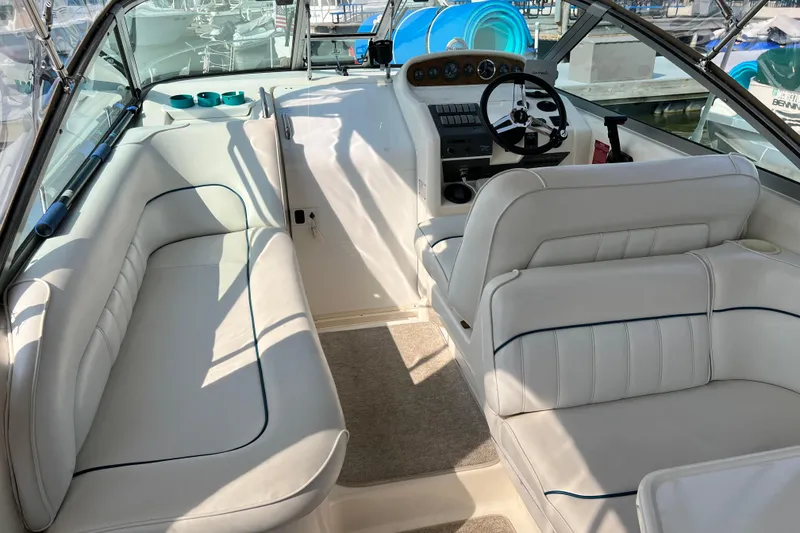 Slide: The Image of 1997 Sea Ray 270 Sundancer interior with white seating and steering console. - 8