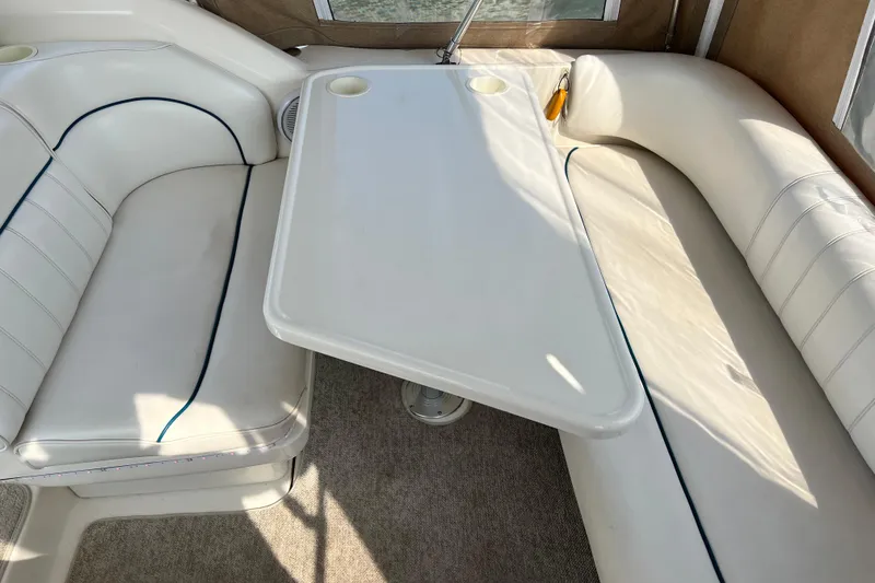 Slide: The Image of Interior seating area of a 1997 Sea Ray 270 Sundancer boat with a white table. - 9