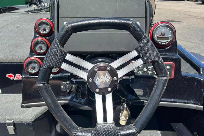 Slide: The Image of Steering wheel and dashboard of a 2018 Bass Cat Lynx boat with gauges and controls. - 11