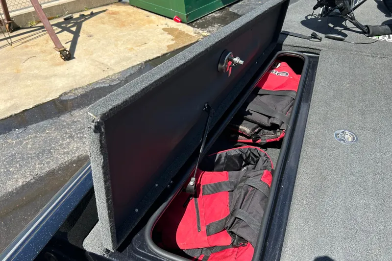 Slide: The Image of 2018 Bass Cat Lynx boat storage compartment with red life jackets inside. - 18