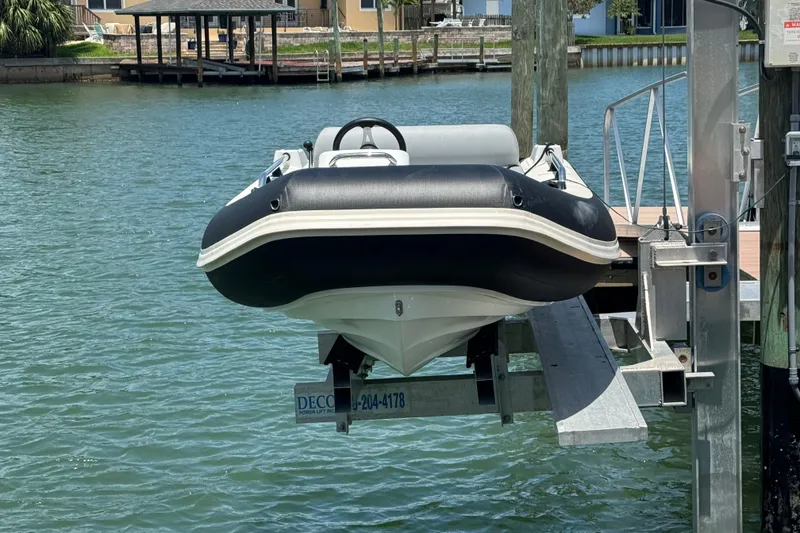 Slide: The Image of 2025 Williams Jet Tenders Sportjet 345 on a dock lift by the water. - 2