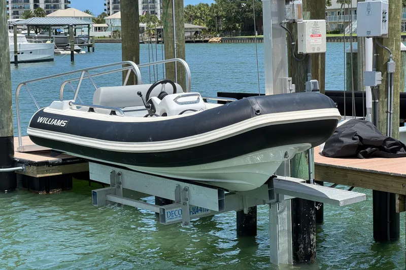 Slide: The Image of 2025 Williams Jet Tenders Sportjet 345 on a dock lift by the water. - 3