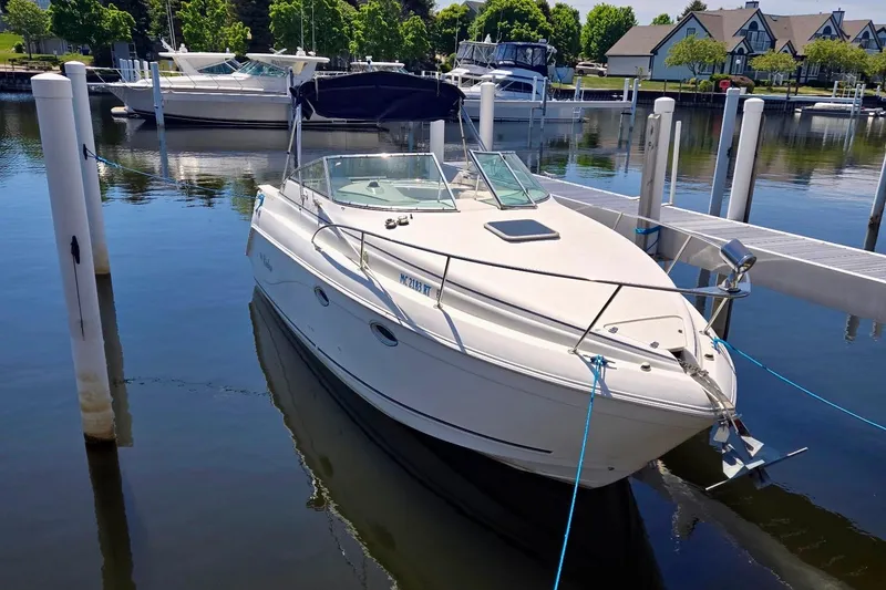 The Image of 1999 Rinker Fiesta Vee 270 boat docked in a serene marina setting. - 0