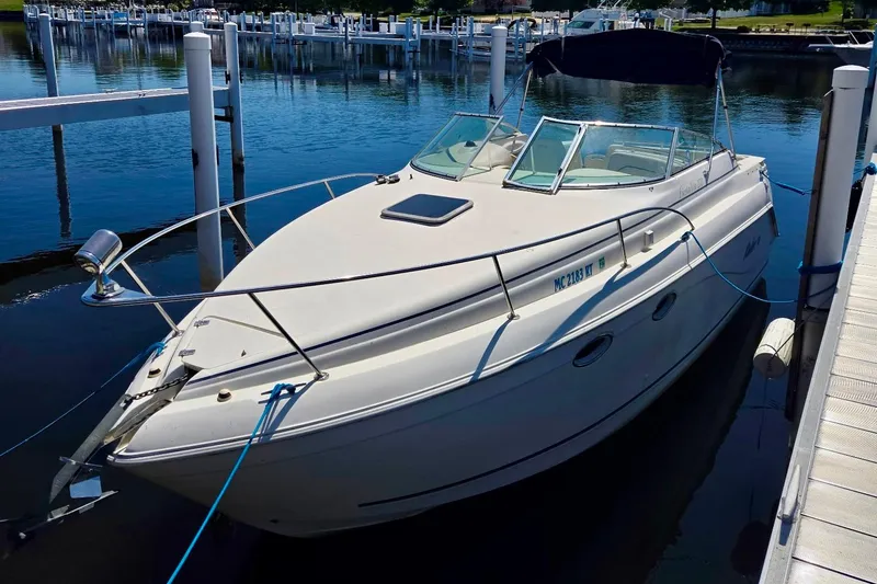 Slide: The Image of 1999 Rinker Fiesta Vee 270 boat docked at marina, sunny day, calm water. - 1