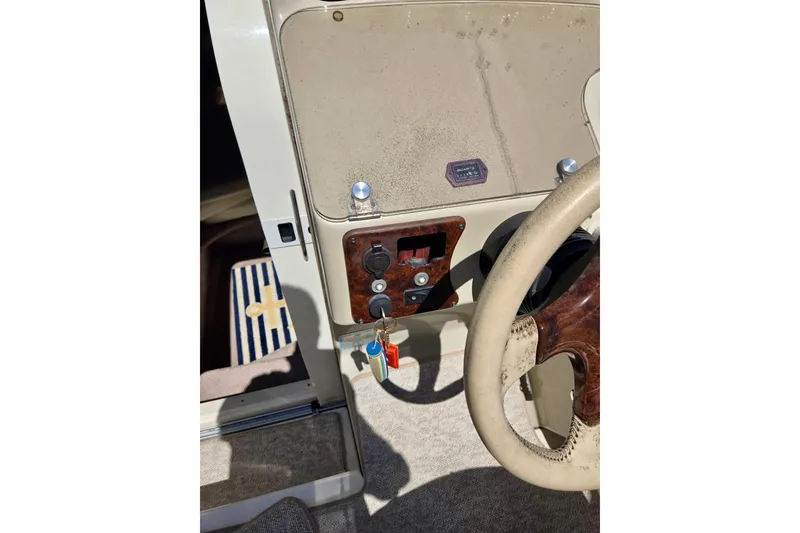 Slide: The Image of 1999 Rinker Fiesta Vee 270 boat dashboard with steering wheel and ignition keys. - 10