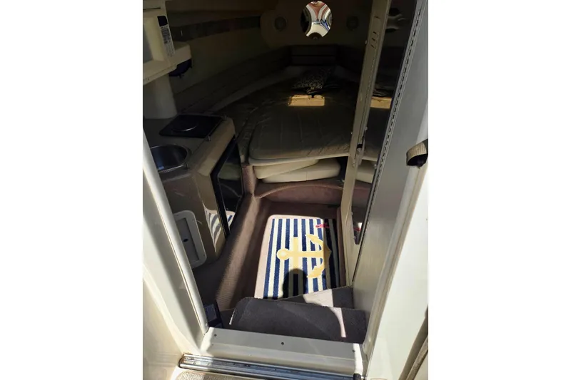 Slide: The Image of 1999 Rinker Fiesta Vee 270 cabin interior with kitchenette and bed. - 12