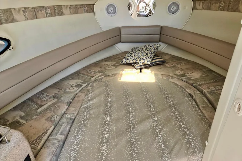 Slide: The Image of 1999 Rinker Fiesta Vee 270 cabin interior with cozy bedding and decorative pillows. - 15