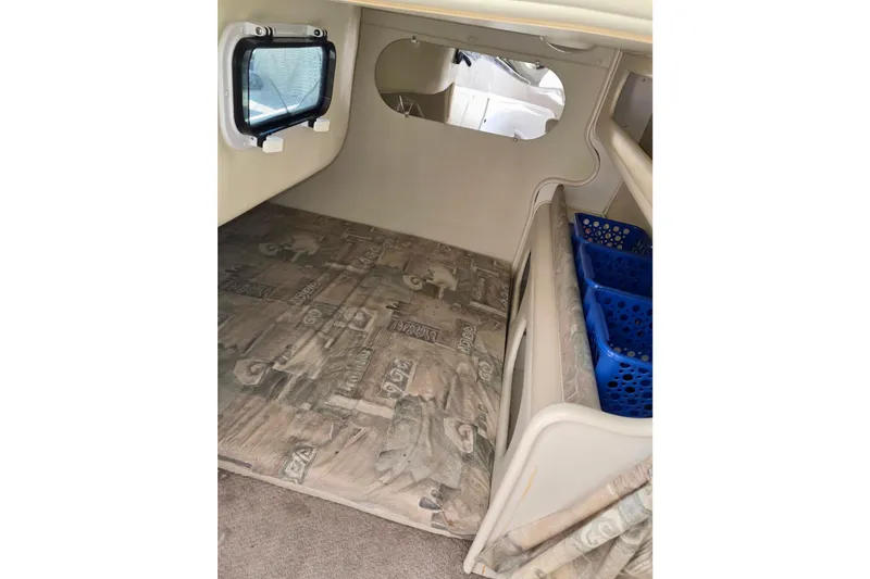 Slide: The Image of 1999 Rinker Fiesta Vee 270 cabin interior with window and storage baskets. - 16