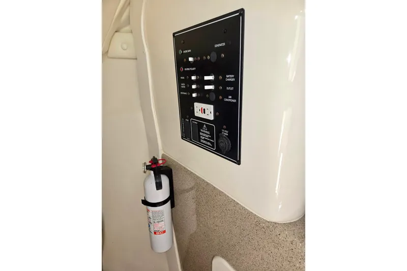 Slide: The Image of Control panel and fire extinguisher on 1999 Rinker Fiesta Vee 270 boat interior. - 17