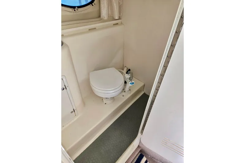 Slide: The Image of 1999 Rinker Fiesta Vee 270 boat bathroom with toilet and compact design. - 19