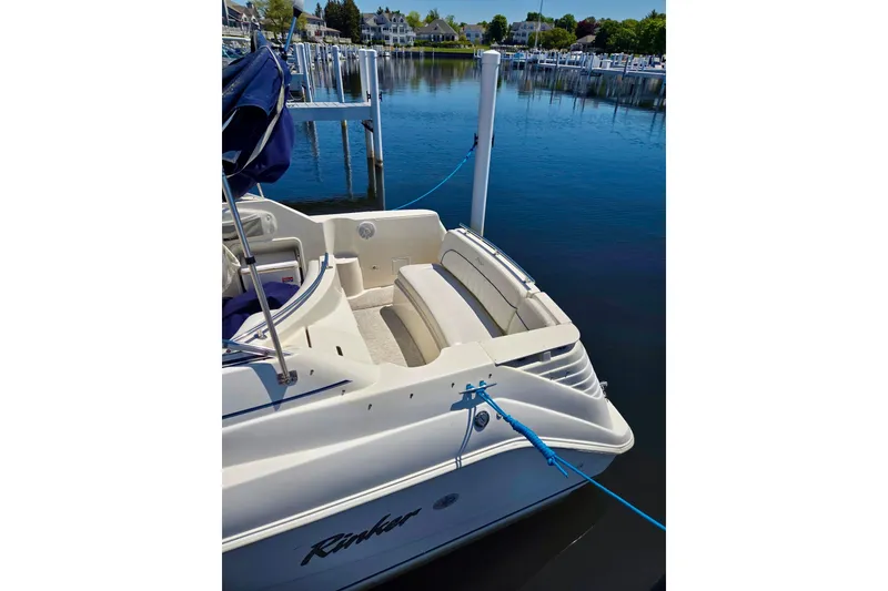Slide: The Image of 1999 Rinker Fiesta Vee 270 boat docked at a marina, featuring a spacious seating area. - 3