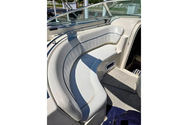 Slide: The Image of 1999 Rinker Fiesta Vee 270 boat interior with curved seating and carpeted floor. - 7