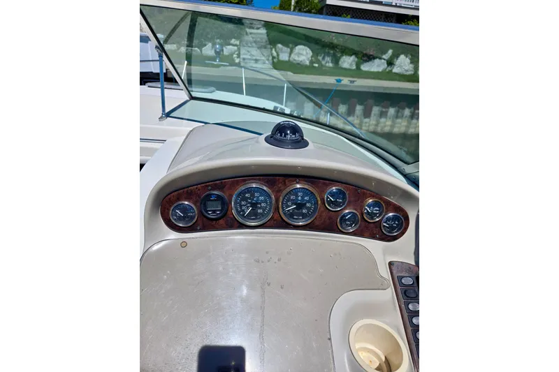 Slide: The Image of Dashboard of a 1999 Rinker Fiesta Vee 270 boat with gauges and compass. - 9