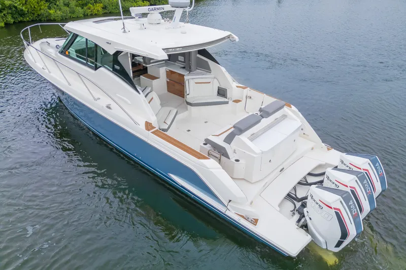 Slide: The Image of 2021 Tiara Sport 43 LE luxury boat with triple outboard engines on calm water. - 46