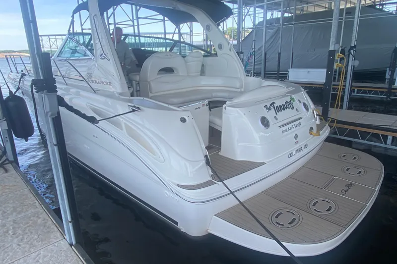 Slide: The Image of 2004 Sea Ray 380 Sundancer docked, showcasing sleek design and spacious seating area. - 13