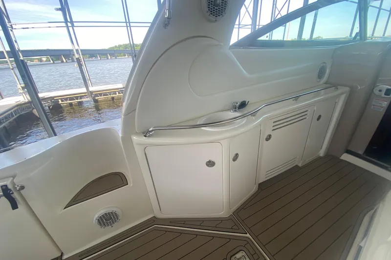 Slide: The Image of 2004 Sea Ray 380 Sundancer interior with cabinets and sink, docked by the water. - 15