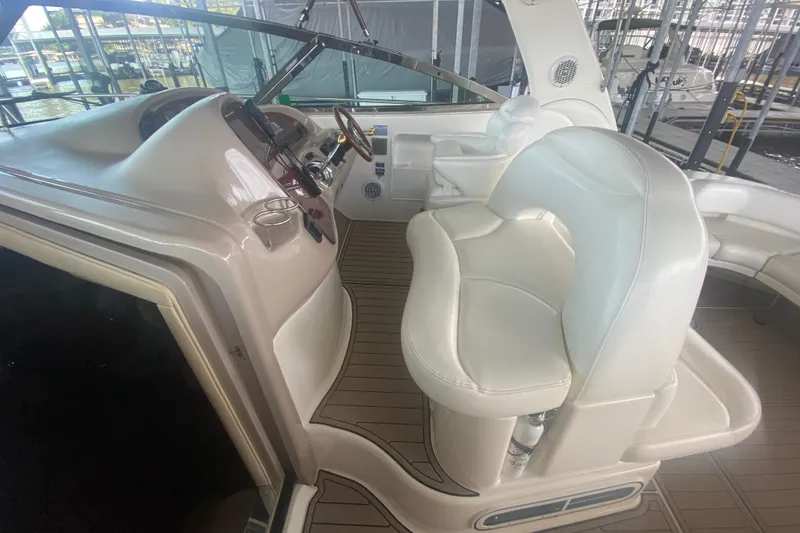 Slide: The Image of 2004 Sea Ray 380 Sundancer cockpit with white leather seating and wooden flooring. - 18