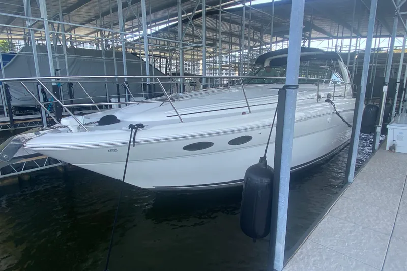 Slide: The Image of 2004 Sea Ray 380 Sundancer docked in a marina, showcasing sleek design and white exterior. - 19