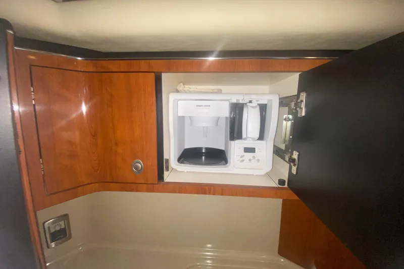 Slide: The Image of Cabinet with coffee maker inside a 2004 Sea Ray 380 Sundancer yacht. - 26