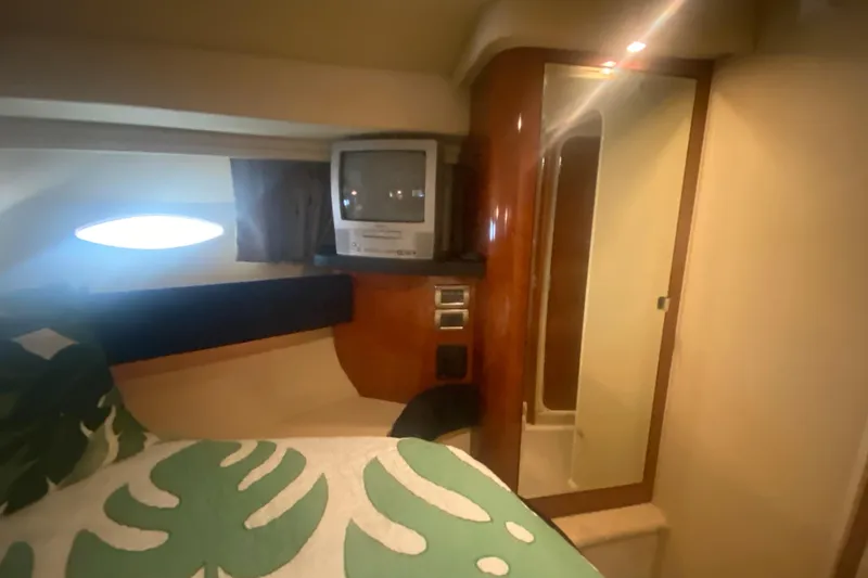Slide: The Image of 2004 Sea Ray 380 Sundancer cabin interior with bed, TV, and porthole window. - 30
