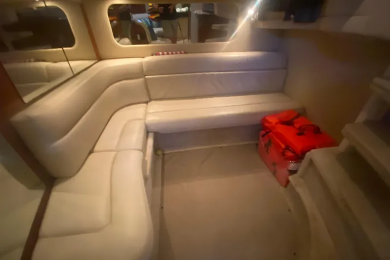Slide: The Image of Interior of 2004 Sea Ray 380 Sundancer with white leather seating and red bags. - 32