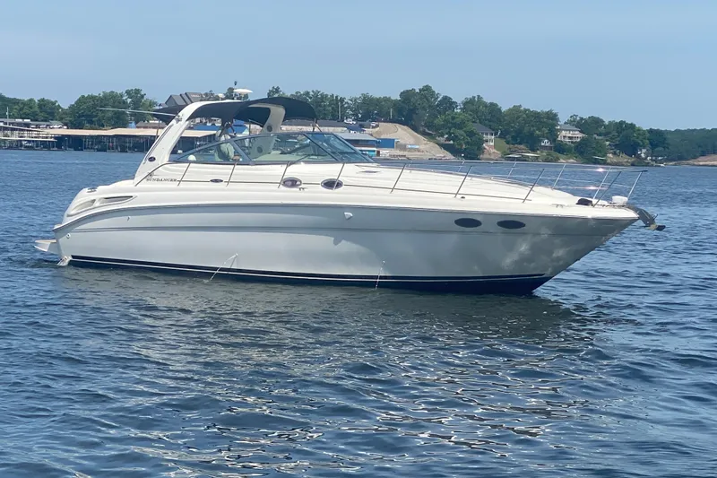 Slide: The Image of 2004 Sea Ray 380 Sundancer yacht on a calm lake with scenic background. - 6