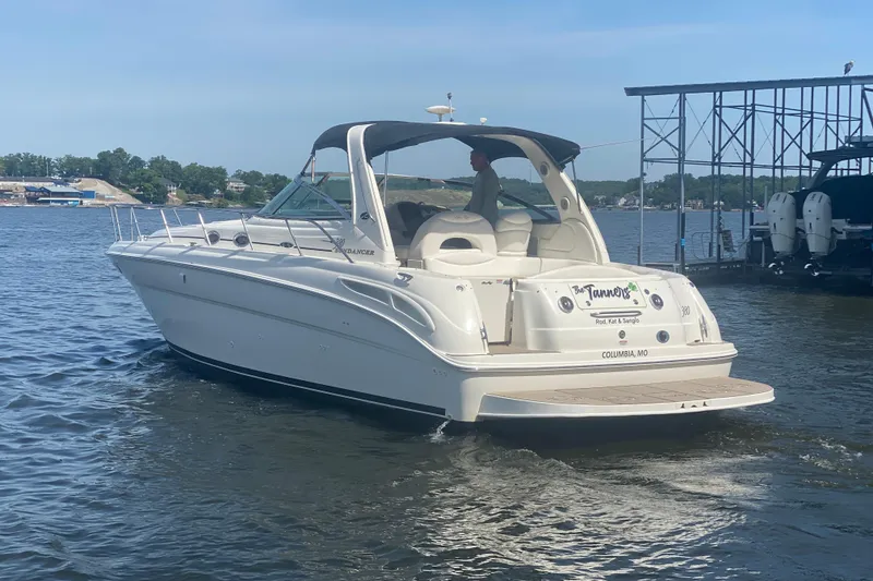 Slide: The Image of 2004 Sea Ray 380 Sundancer yacht cruising on a sunny lake near a marina. - 9