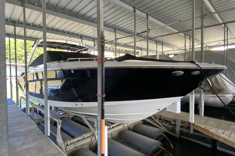 Slide: The Image of 2014 Cruisers 328 Black Diamond boat docked in covered marina. - 10