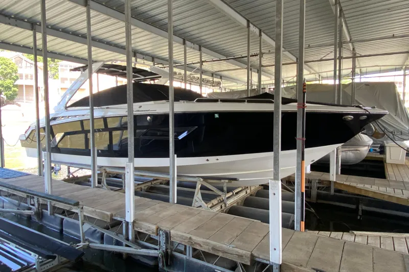 Slide: The Image of 2014 Cruisers 328 Black Diamond boat docked in covered marina. - 11
